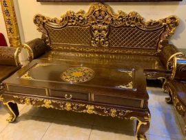 Mặt bàn khung tranh dày dặn đục họa tiết trống đồng, dát vàng nổi bật. Chương ghế đục hoa lá tây và hoa sen tinh xảo. Vách đục quả trám sang trọng