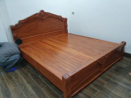 Giường gỗ Gụ màu nâu cánh gián nổi bật trong không gian phòng ngủ.