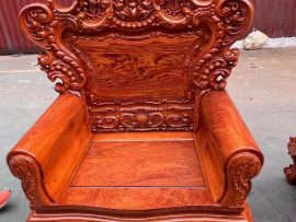 Vách tựa lưng để trơn với đường vân gỗ mịn, hoa văn độc đáo, đỉnh ghế đục bông hồng cuốn hút - điểm nhấn cực sang trọng của mẫu bàn ghế này