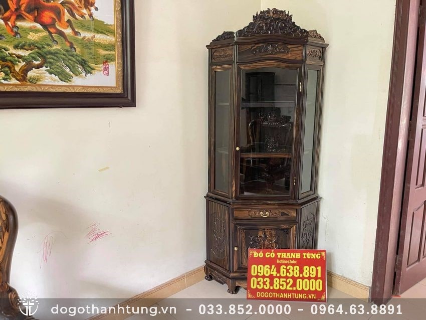 Tủ rượu góc gỗ mun 1 tầng kính và 1 tầng ngăn kéo. Tủ được đục chạm hoa văn truyền thống, phun PU giữ nguyên vân gỗ độc đáo