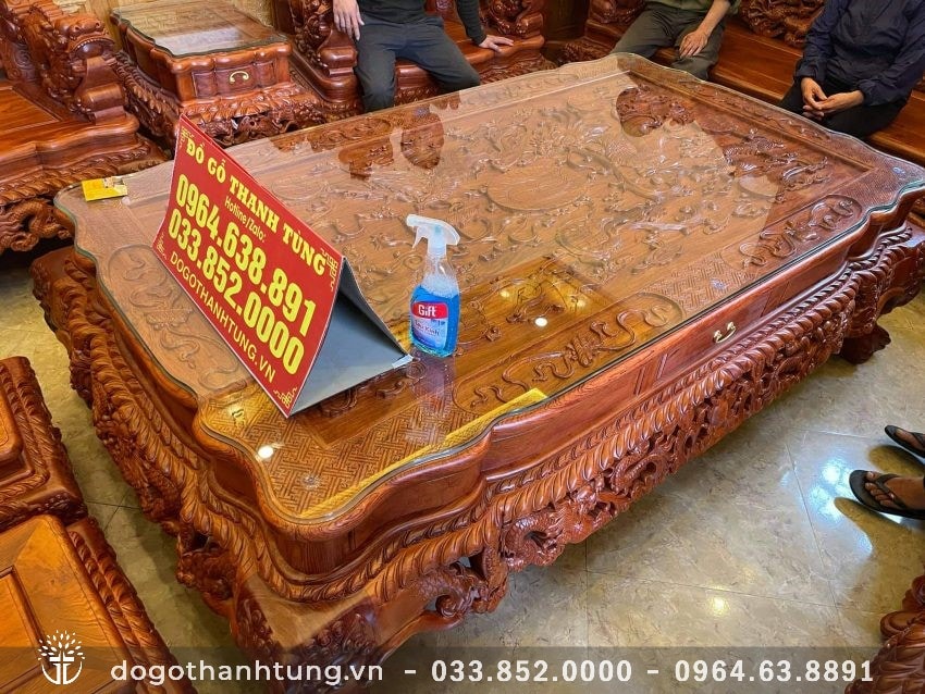 Mặt bàn nguyên tấm đục nổi Tứ Linh quần tụ. Ván dày 5 phân. Có thêm tấm kính trong suốt đặt trên tăng vẻ sang trọng và bảo vệ tốt mặt gỗ.