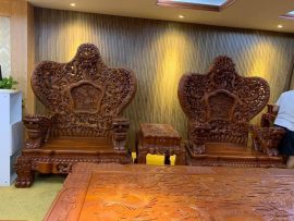 Hình ảnh ghế đơn và đôn kẹp trong bộ bàn ghế Cửu Long Bát Mã. Mặt bàn chạm nổi tứ linh quần tụ