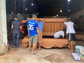 Khách hàng mua sập gụ đang kiểm tra mộc